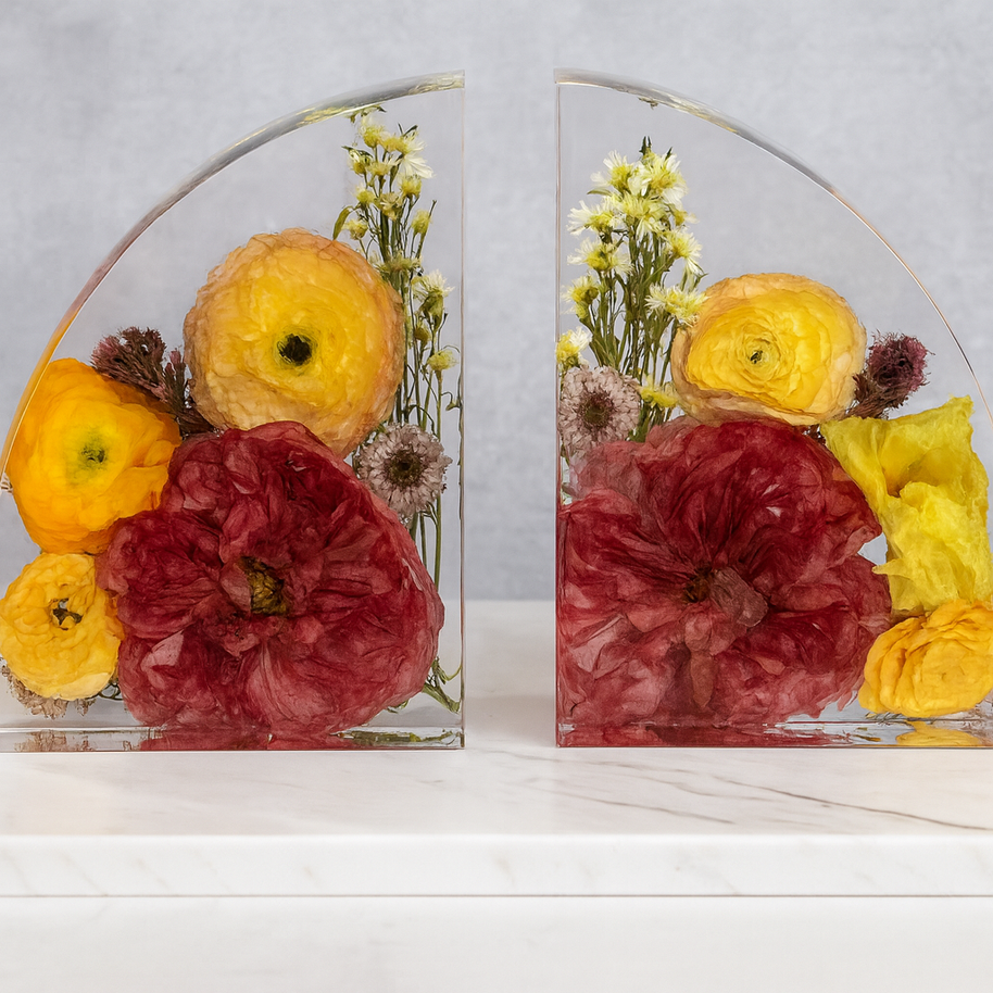 Decorative floral arrangement in clear glass frames on a white surface with a light gray background